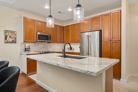 Your fully-equipped kitchen features gleaming granite countertops, stainless steel appliances, and warm wood cabinets—perfect for creating memorable meals together.