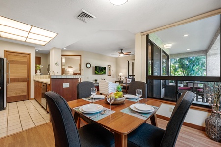 Savor meals together at your elegant dining table, perfectly positioned to catch tropical breezes and lush garden views through expansive windows.