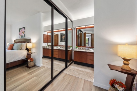 Your bedroom opens to a spa-like bathroom with double vanities and granite countertops. Mirrored closet doors reflect warm lighting and thoughtful touches, creating a serene space for your morning routine.