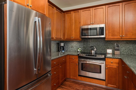 Full kitchen with breakfast bar, granite counters, and stainless steel appliances