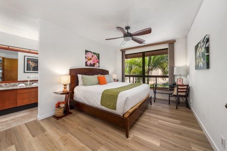 Unwind in your serene bedroom where tropical palms frame your window and crisp linens invite restful nights beneath the gentle ceiling fan.