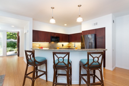 - Pull up a seat at the granite breakfast bar with elegant wooden stools and pendant lighting - Perfect for quick bites, morning coffee, or chatting with the cook - Kitchen’s sleek design and warm finishes bring charm to every meal