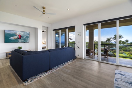 - Living space with large windows offering sweeping ocean and garden views   - Open layout flows effortlessly to the covered lanai for outdoor living   - Perfect for relaxing after a day exploring the island surroundings