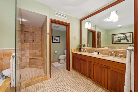 Your spacious bathroom features warm wood finishes, dual sinks with granite countertops, and a beautifully tiled walk-in shower—your personal retreat after a day of adventure.
