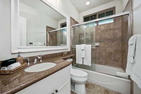 Refresh in your private bathroom featuring granite countertops, glass shower doors, and plush towels awaiting your arrival.