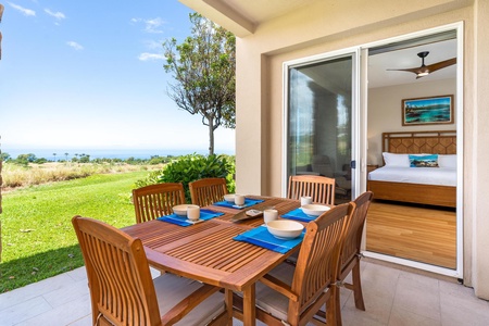- Outdoor dining set for six with wooden chairs and blue placemats positioned by sliding doors - Scenic backdrop of lawn and ocean horizon enhances mealtime enjoyment - Easy indoor access from the bedroom makes outdoor dining simple and convenient