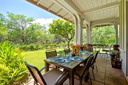 Covered lanai with garden views, dining table, and BBQ