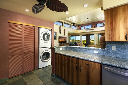 Convenient in kitchen laundry with stacked washer and dryer for easy access.