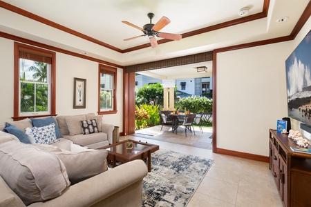 - Living room with comfortable seating and open air access to covered patio dining   - Ceiling fan and neutral tones enhance the airy, relaxing atmosphere   - Perfect for lounging while enjoying fresh breezes and garden views