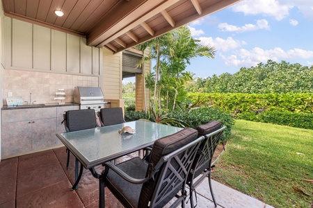 Your private covered patio features a full outdoor kitchen and dining area, perfect for grilling and entertaining while overlooking lush tropical gardens.