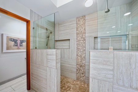 - Elegant walk in dual shower with glass panels and natural stone tile accents - Built in niches provide convenient space for toiletries and personal care - Spa inspired retreat just steps from the bedroom for ultimate relaxation
