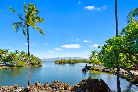 Serene lagoon view framed by Scenic golf course with sand traps and a peaceful pond.greenery and palm trees.
