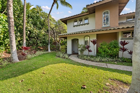 Mediterranean-style villa nestled among swaying palms and tropical gardens, featuring warm stucco walls and distinctive tile roofing in a serene island setting.