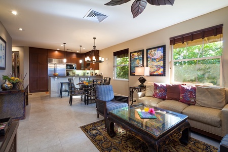 - Spacious open concept layout connects the living room, dining area, and chef’s kitchen - Dark wood finishes and vibrant wall art add richness and warmth - Ideal for group gatherings with plenty of seating and natural light