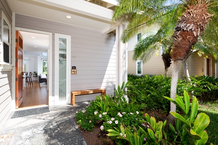 Welcoming front entry framed by beautiful tropical landscaping.