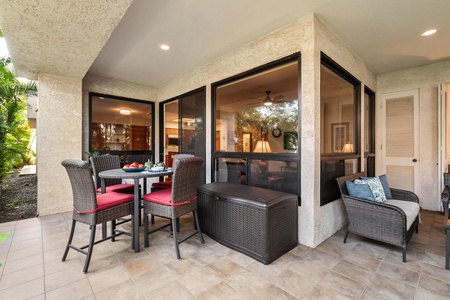 Dine al fresco on your private covered patio, where wicker seating and red cushions create the perfect spot for morning coffee or evening meals.