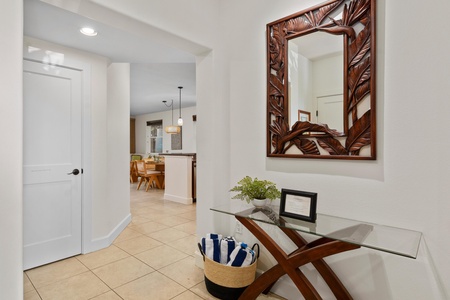 Step into your elegant entryway where tropical-inspired décor and warm wood accents welcome you home after island adventures.