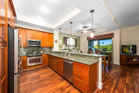 Full kitchen with breakfast bar, granite counters, and stainless steel appliances