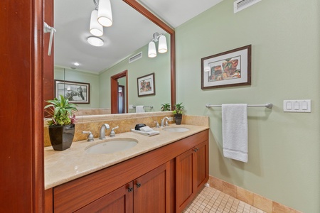 Step into your serene bathroom, where soft green walls and warm wood accents create a calming escape. Twin sinks offer plenty of space, while fresh towels and thoughtful touches await your arrival.