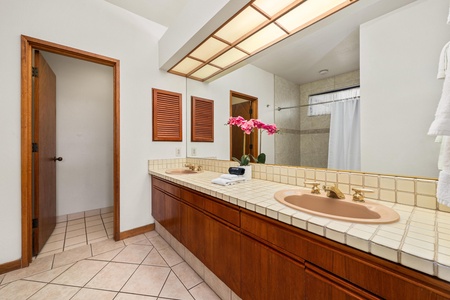 Your spacious bathroom features warm wood accents, natural lighting, and elegant tile work for a serene morning routine.