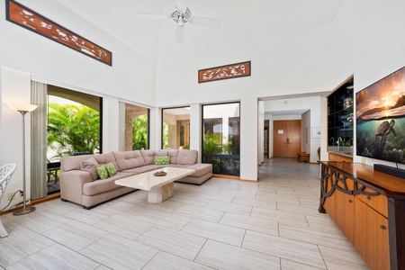 - Natural light & garden views surround this open concept living room with sleek tile floors - Tall ceilings & modern fans create a cool, comfortable vibe throughout the day - Seamless flow from entryway to living to lanai makes for easy vacation living