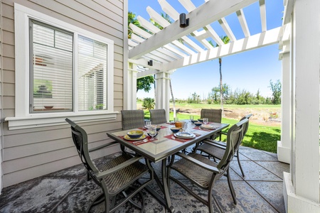 - Charming patio dining space styled with woven chairs and a sleek tile top table - Surrounded by fresh greenery and open skies for a true island vibe - Shaded pergola makes it ideal for both sunny lunches and cool evenings