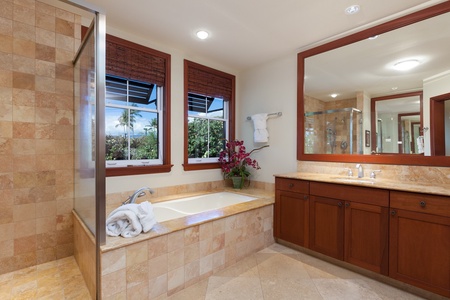 - Stylish soaking tub and spacious vanity with rich wood cabinetry - Large mirror and windows create a bright and inviting bathroom space - Thoughtful layout offers comfort and relaxation for guests
