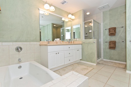 - Enjoy a spacious bathroom with a soaking tub and glass enclosed walk in shower   - Dual sink vanity with plenty of counter space for convenience and comfort   - Elegant lighting fixtures brighten the serene coastal green walls