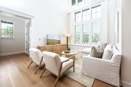 Sink into plush seating and unwind in your bright, airy living space with soaring ceilings and warm wood floors.