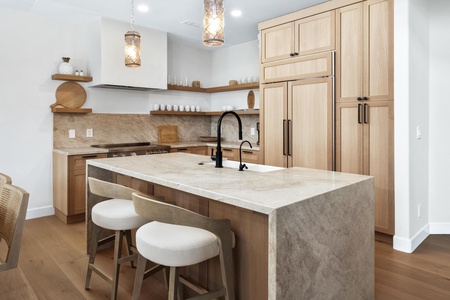 Your modern kitchen features warm wood cabinetry, marble countertops, and a spacious island perfect for morning coffee or meal prep.
