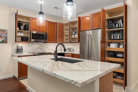 Your gourmet kitchen features stunning marble countertops, warm wood cabinetry, and premium appliances for culinary adventures.