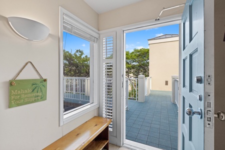 The entryway features a sunny private terrace overlooking lush tropical greenery