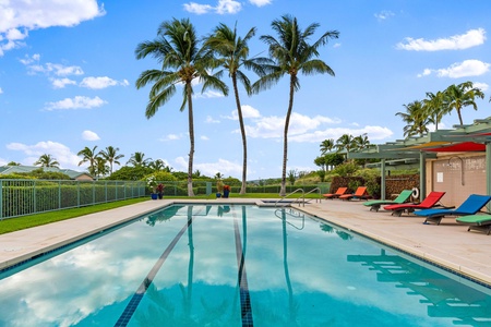 Sparkling lap pool framed by swaying palms and clear blue skies.