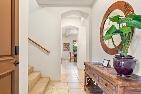 Step into your elegant foyer where warm wood details and tropical greenery create a welcoming first impression of your vacation home.