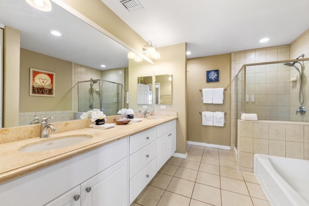 Your spacious bathroom offers dual vanities and a generous walk-in shower, with plush towels waiting to wrap you in comfort after a refreshing rinse.