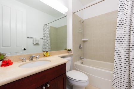 - Full bathroom featuring a tiled shower tub combo and wide vanity with mirror - Bright lighting makes getting ready simple and convenient for every guest - Neutral tones and modern fixtures create a clean and welcoming space