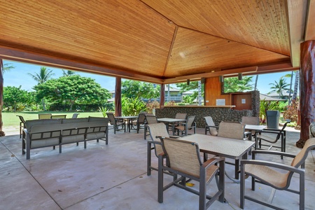 Relax in your covered outdoor pavilion where warm wood tones and comfortable seating create the perfect tropical gathering space.