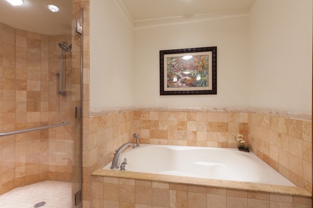 - Stylish soaking tub surrounded by warm toned tiles for a cozy retreat - Decorative framed artwork adds charm and enhances the relaxing atmosphere - Perfect space to unwind after a day of activities or sightseeing