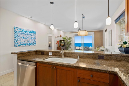 Your open kitchen flows seamlessly into the living space, where granite countertops and ocean views create the perfect backdrop for preparing meals.