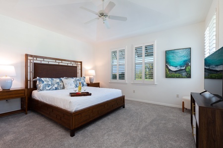 - Spacious bedroom with a king bed framed by coastal inspired linens and decor - Natural light flows through shuttered windows with views of greenery outside - Plush carpet and neutral tones create a peaceful retreat for rest