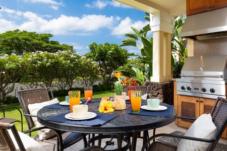 - Patio dining table set with colorful drinks and tropical fruit centerpiece   - Surrounded by beautiful greenery and blooming plants for a vibrant atmosphere   - Perfect spot for leisurely breakfasts or sunny afternoon snacks