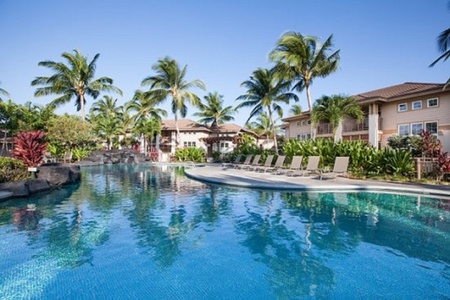 Stylish lagoon style pool lined with loungers and palms