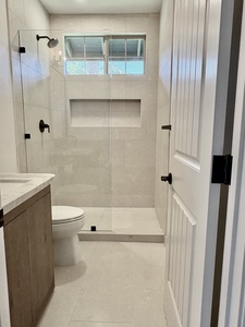 Your beautifully remodeled second bathroom features limestone floors and shower, an oak vanity, leathered quartzite countertops, and Rohl fixtures