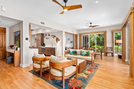 - Bright open living space with warm wood flooring & a colorful rug adding vibrant charm - Comfortable seating with modern designs perfect for gathering & conversation - Open layout connects kitchen & dining while sunlight fills the room throughout the da