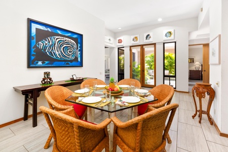 - Vibrant island artwork, beautiful garden views, and bright interiors define this dining area - Seat six comfortably at the square glass top table under soft, recessed lighting - Enjoy every meal surrounded by style, sunlight, and tropical charm