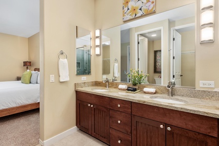 Remodeled primary bathroom with double vanity, walk-in shower, and soaking tub