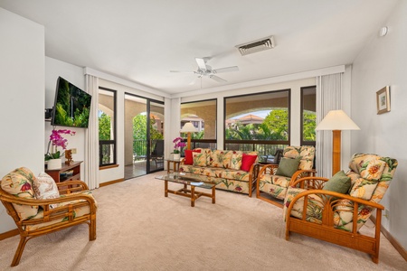 Unwind in your bright living room with tropical furnishings and peaceful garden views through floor-to-ceiling windows.