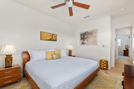 - Elegant retreat with a king bed, matching nightstands, and decor accents - Golden accents and artistic prints create a warm atmosphere - Perfect spot to unwind under the ceiling fan after a day of exploring