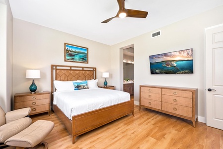 - Comfortable bedroom with warm wood bed frame matching dresser & nightstands for a cohesive style - Framed coastal artwork & mounted TV add charm and entertainment options - Ceiling fan and direct access to ensuite bathroom enhance comfort and convenienc