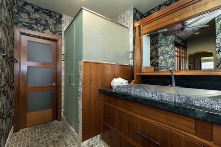 Bathroom with stone countertop design and frosted glass shower.